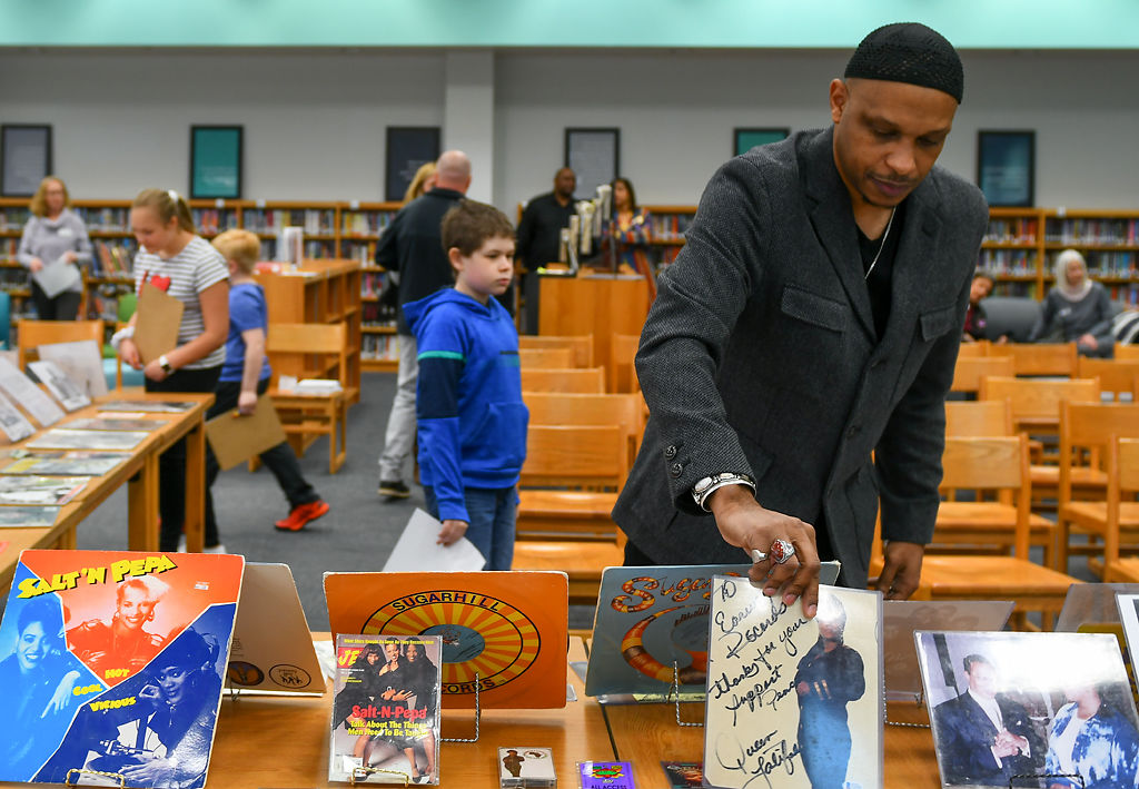 Khalid el-Hakim, curator and founder of the Black History 101 Mobile Museum, places a signed photo of Queen Latifah